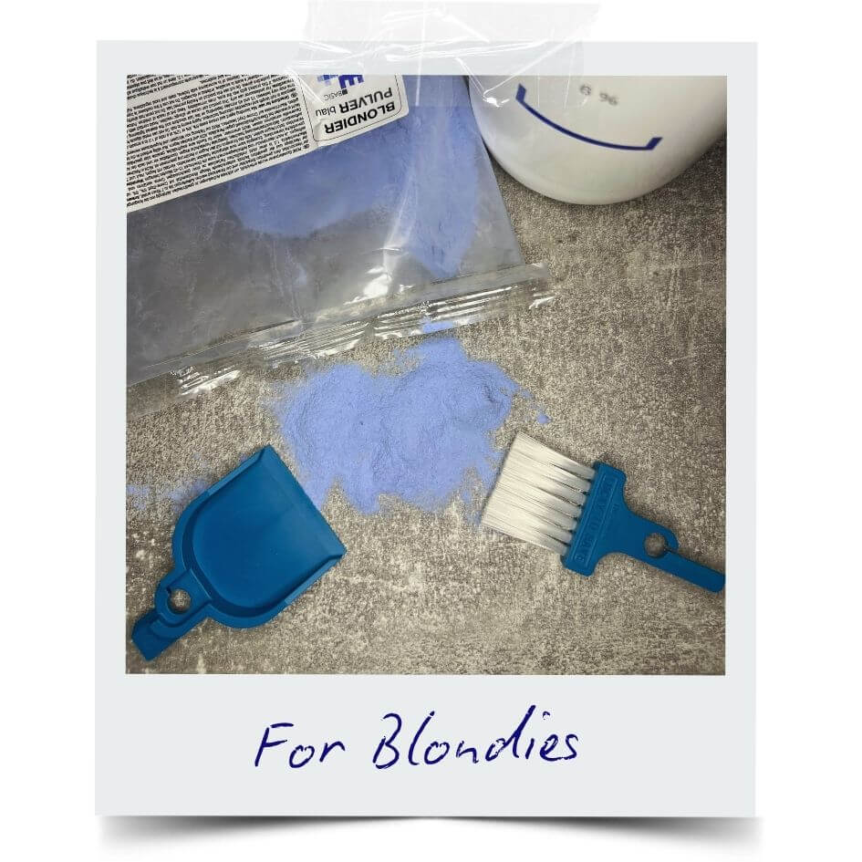 LUCKY TO HAVE® Bora Bora smallest broom and dustpan set next to spilled blue bleaching powder, showing fine powder scattered from a hair lightener product on a surface.