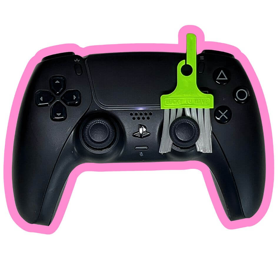 LUCKY TO HAVE® Sour Pop – the smallest broom in the world – sweeping crumbs and fine dust off a PlayStation controller, perfect for gamers who care about clean gear and tiny details, and fun to use as a mini fidget toy between rounds.