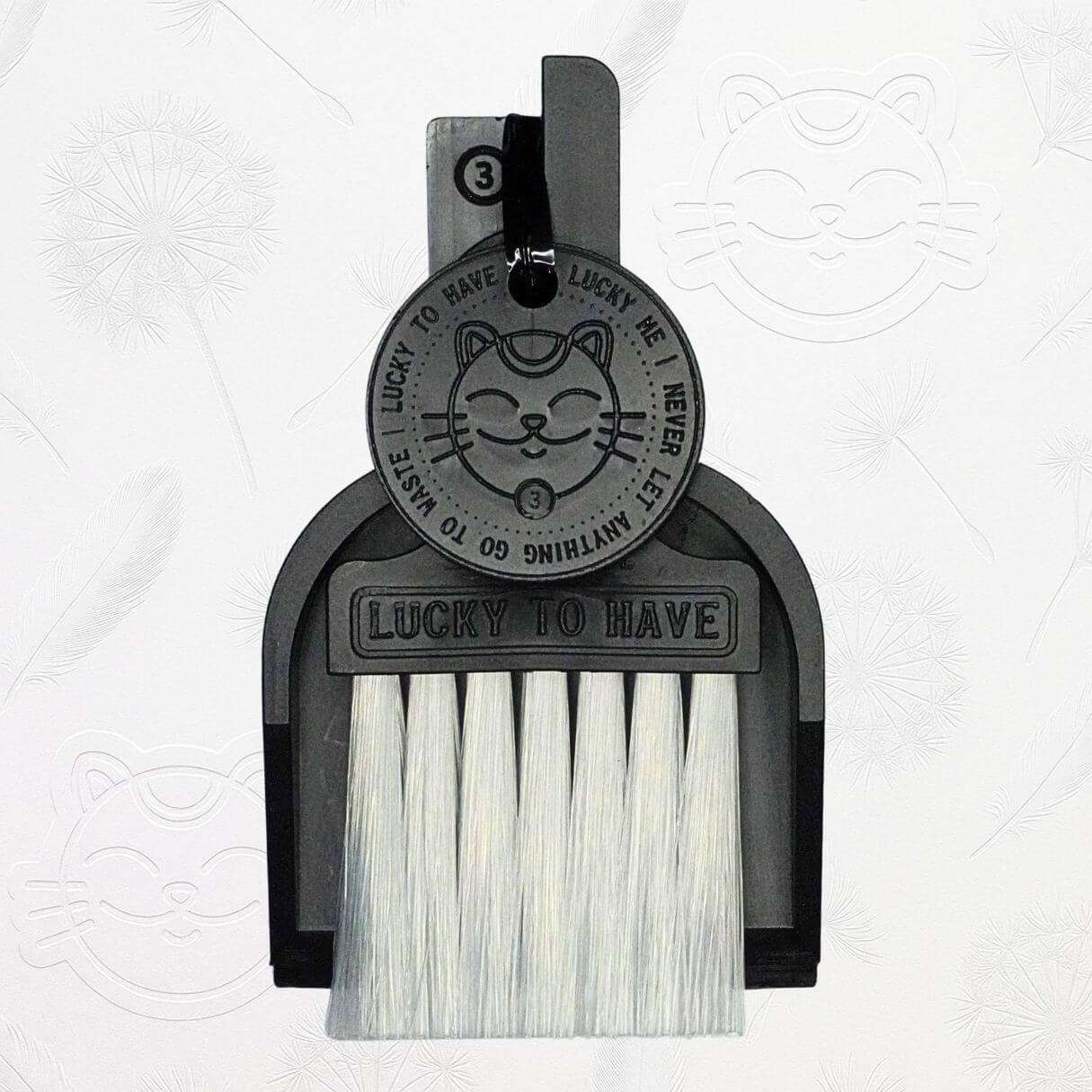 LUCKY TO HAVE® black mini dustpan set presented in front of the signature brand-style wallpaper.