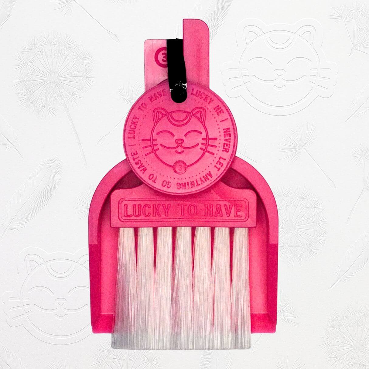 LUCKY TO HAVE® pink mini dustpan set presented in front of the signature brand-style wallpaper.