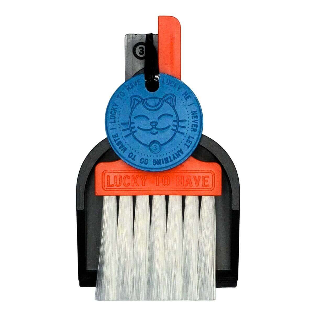 Mix Your LUCKY TO HAVE® - Individueller Mini-Besen im bunten Design. Das Bild zeigt ein zusammengestecktes Set mit schwarzer Schaufel, orangem Besen und blauer Münze auf weissem Hintergrund. Ein funktionales Design-Objekt für feine Dinge.