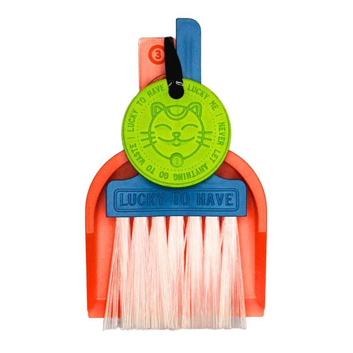 LUCKY TO HAVE® mini sweeper: A colorful individual set featuring a brush a tray and a lucky-charm in contrasting colors on a white background. The compact mini broom for quick clean-ups and lucky moments.