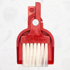 LUCKY TO HAVE® Lucky Bordeaux – the world’s smallest broom and pan set in bordeaux, shown in front of the signature brand-style wallpaper.