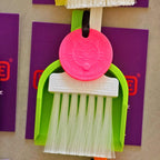 LUCKY TO HAVE® mini broom set for powders and coffee grounds, with a white brush, lime green dustpan and pink Lucky Coin.